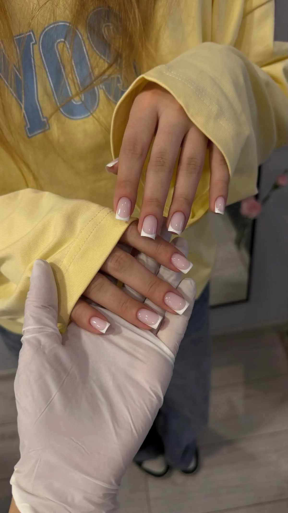 Both hands with a fresh square French manicure